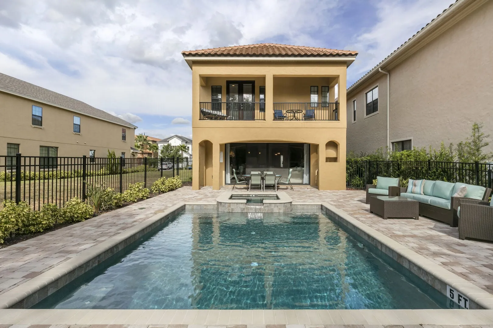 The Perfect Getaway's private pool and spillover spa with the two-story villa and covered balcony behind it