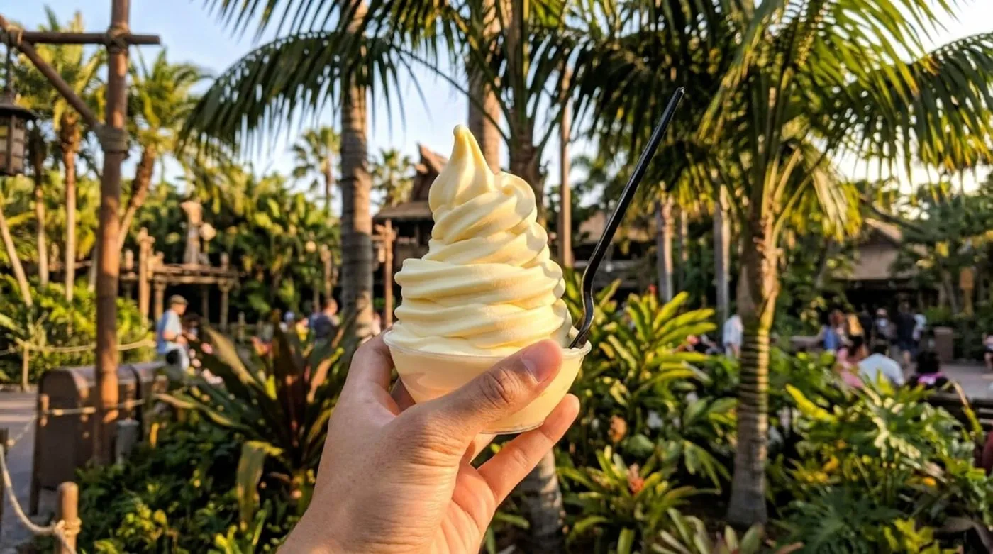 A Dole Whip soft-serve held up against palm trees
