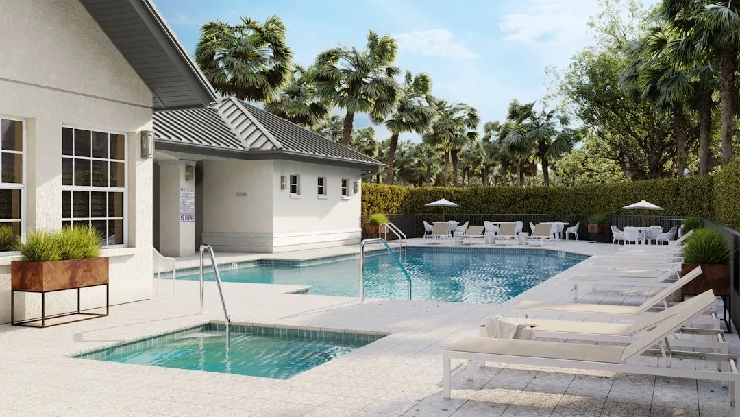 A luxurious pool area with sun loungers and building.